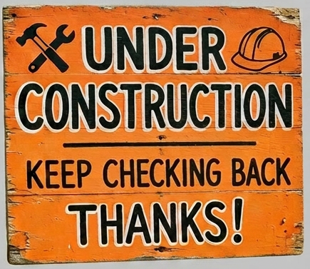 Orange under construction sign with tools and helmet icons on a fence at a building site